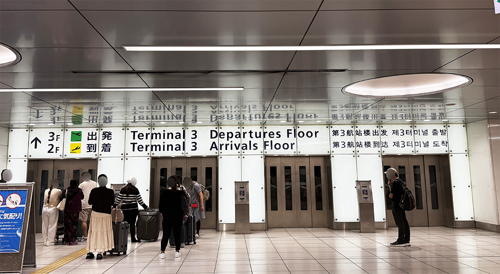 羽田空港第3ターミナル駅の改札を出てすぐの場所にある、4基のエレベーターが並ぶ広々としたロビー。