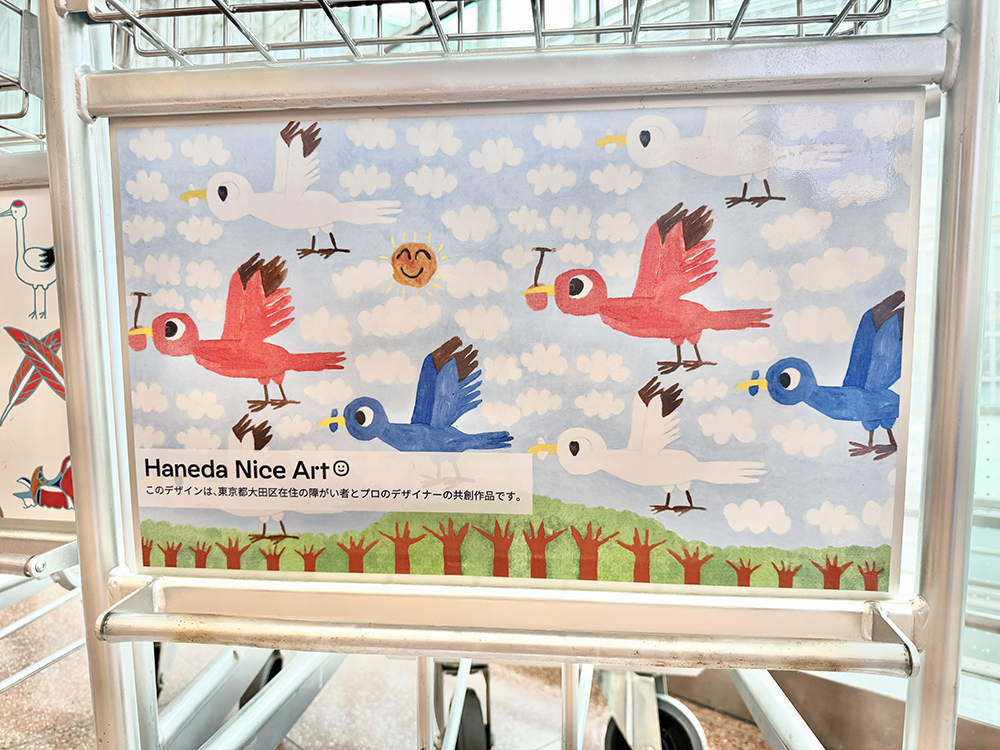 カラフルな鳥のイラストが大きく描かれた、地域連携プロジェクトの手荷物用デザインカート。