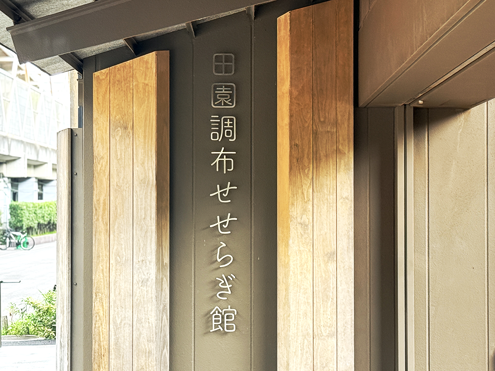 田園調布せせらぎ館、と縦書きで文字が刻まれた木目調の館名看板