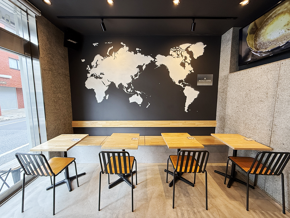 壁面に大きな世界地図が描かれたおしゃれなバックルコーヒーの店内客席