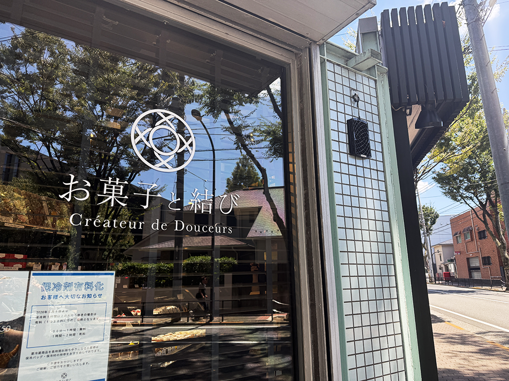大田区下丸子にある洋菓子店「お菓子と結び(Créateur de Douceurs)」の、ロゴマークが描かれたガラス張りのシックな店舗入り口