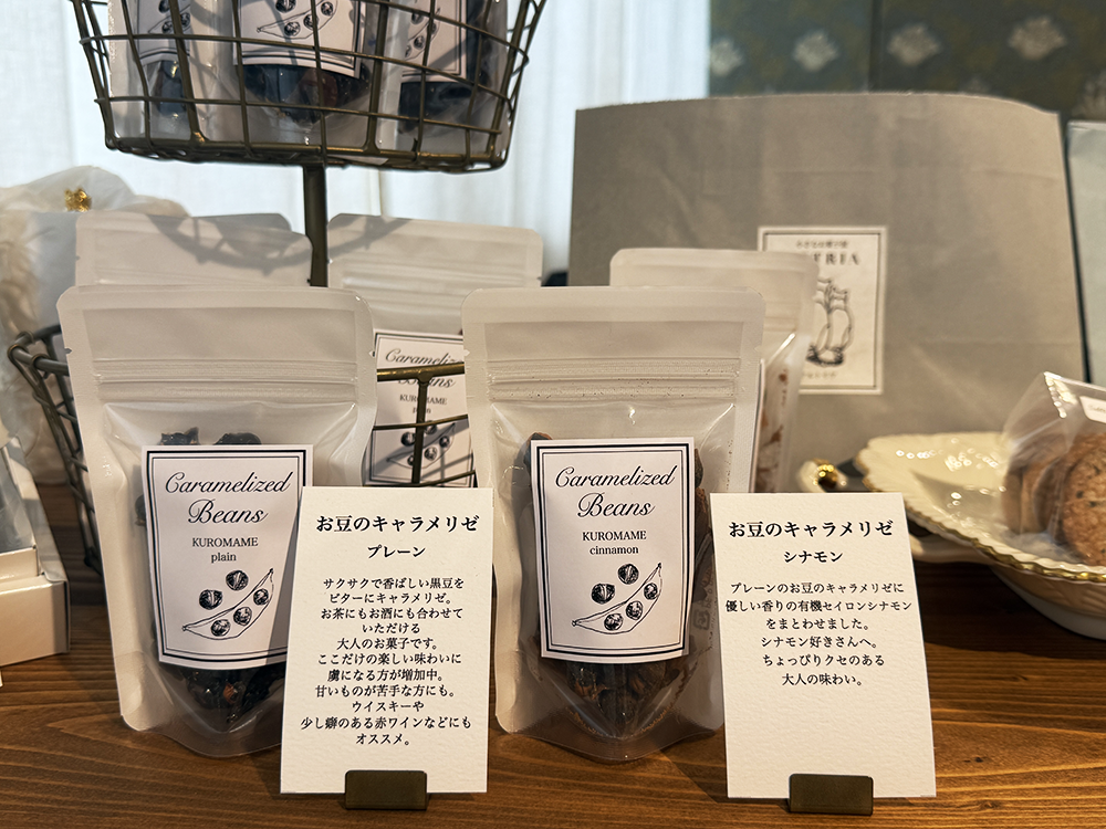 下丸子のARTRIA(アルトリア)で販売されている「お豆のキャラメリゼ」。プレーンとシナモンの2種類のフレーバーが、白いチャック付きの袋に入って並んでいるディスプレイ