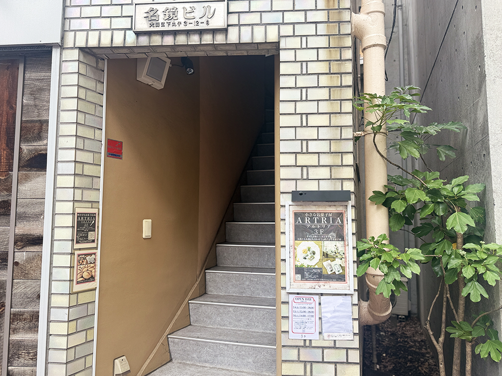 ARTRIAが入る大田区下丸子の「名鏡ビル」の外観。1階の蕎麦屋の横にある、3階の店舗へと続くレトロなレンガ調の階段入り口