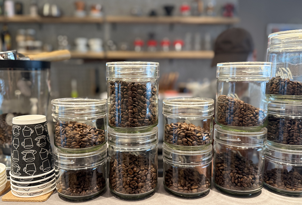 カウンターに整然と並べられた様々な産地のコーヒー豆が入ったガラス製のキャニスター