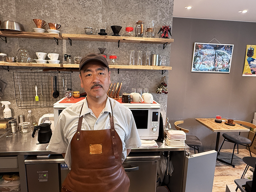 レザーエプロンを身にまといクロス珈琲館の厨房に立つ店主の中島稔充さん