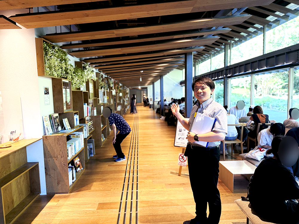 せせらぎ館の居心地の良い木製通路で、笑顔で案内をする西嶋館長