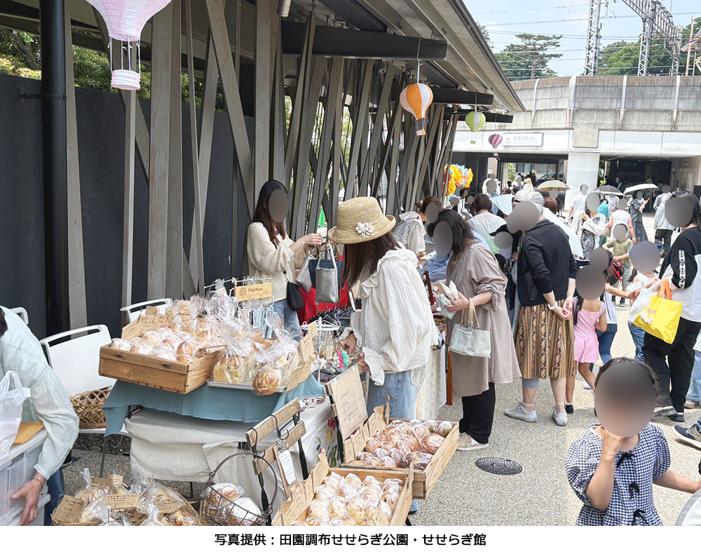 せせらぎ館の前で地元のパンや焼き菓子などが販売され、多くの地域住民で賑わうせせらぎマルシェの様子